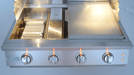 Stainless steel gas grill with four burners on a white background