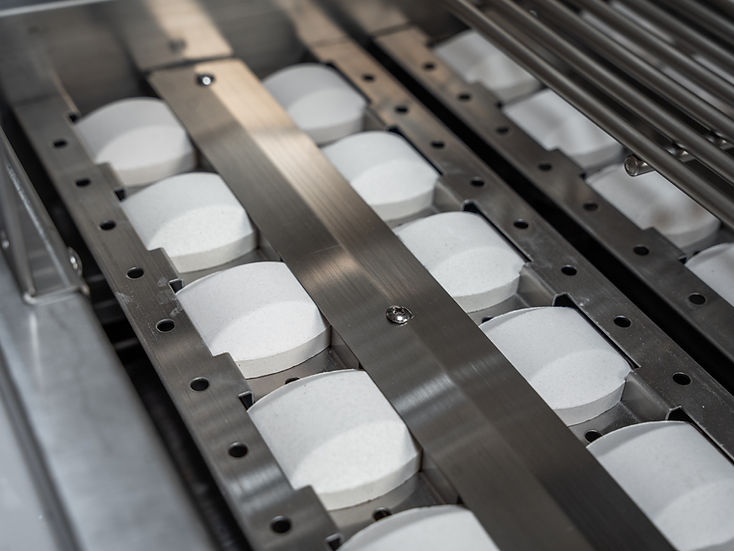 Row of white cylindrical objects on a metal rack