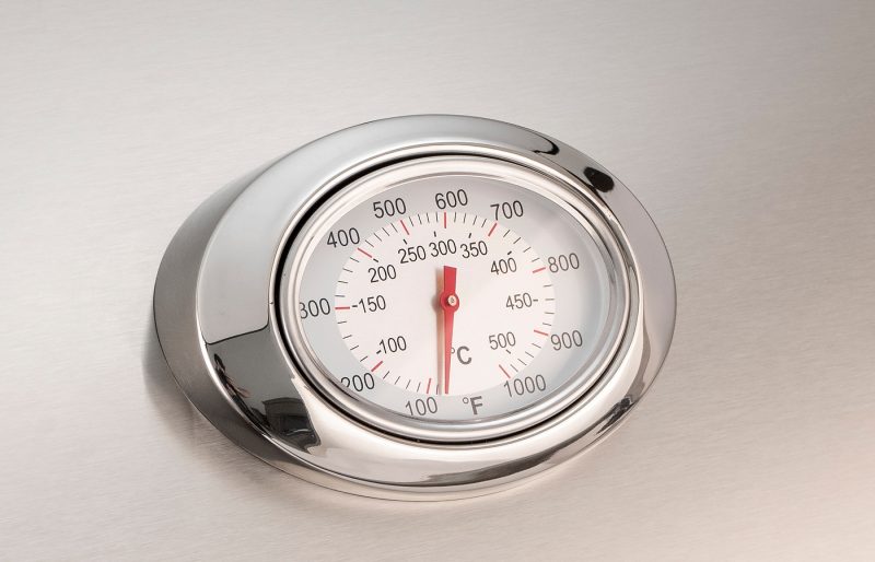 Metallic oven thermometer on a white background