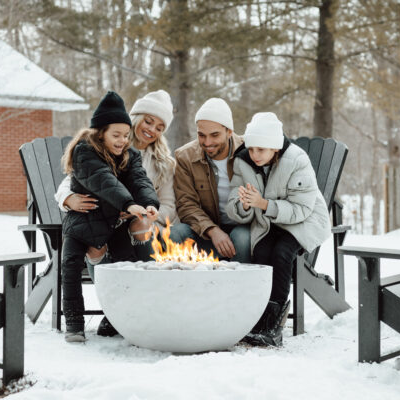Family gathered around a fire pit in the snow