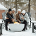 Family gathered around a fire pit in the snow