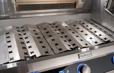 Stainless steel grilling surface with FireMagic branding on a kitchen appliance.