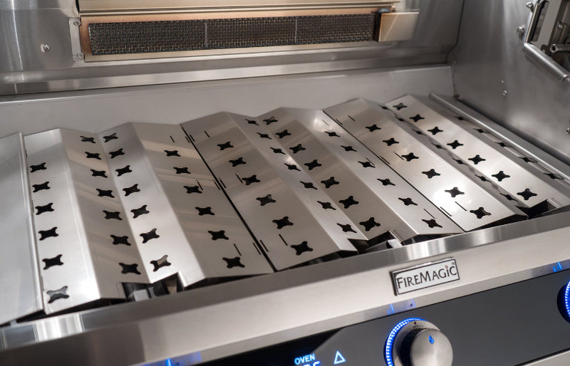 Stainless steel grilling surface with FireMagic branding on a kitchen appliance.
