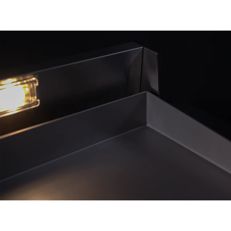 Close-up of a black metal frame with a light source inside, on a white background
