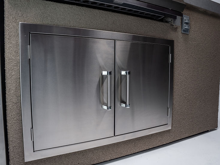 Stainless steel double door grill embedded in a stone wall