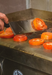 Tomatoes being flipped on a griddle