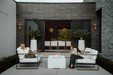 Two people sitting on outdoor furniture near a fire pit in a modern patio setting.